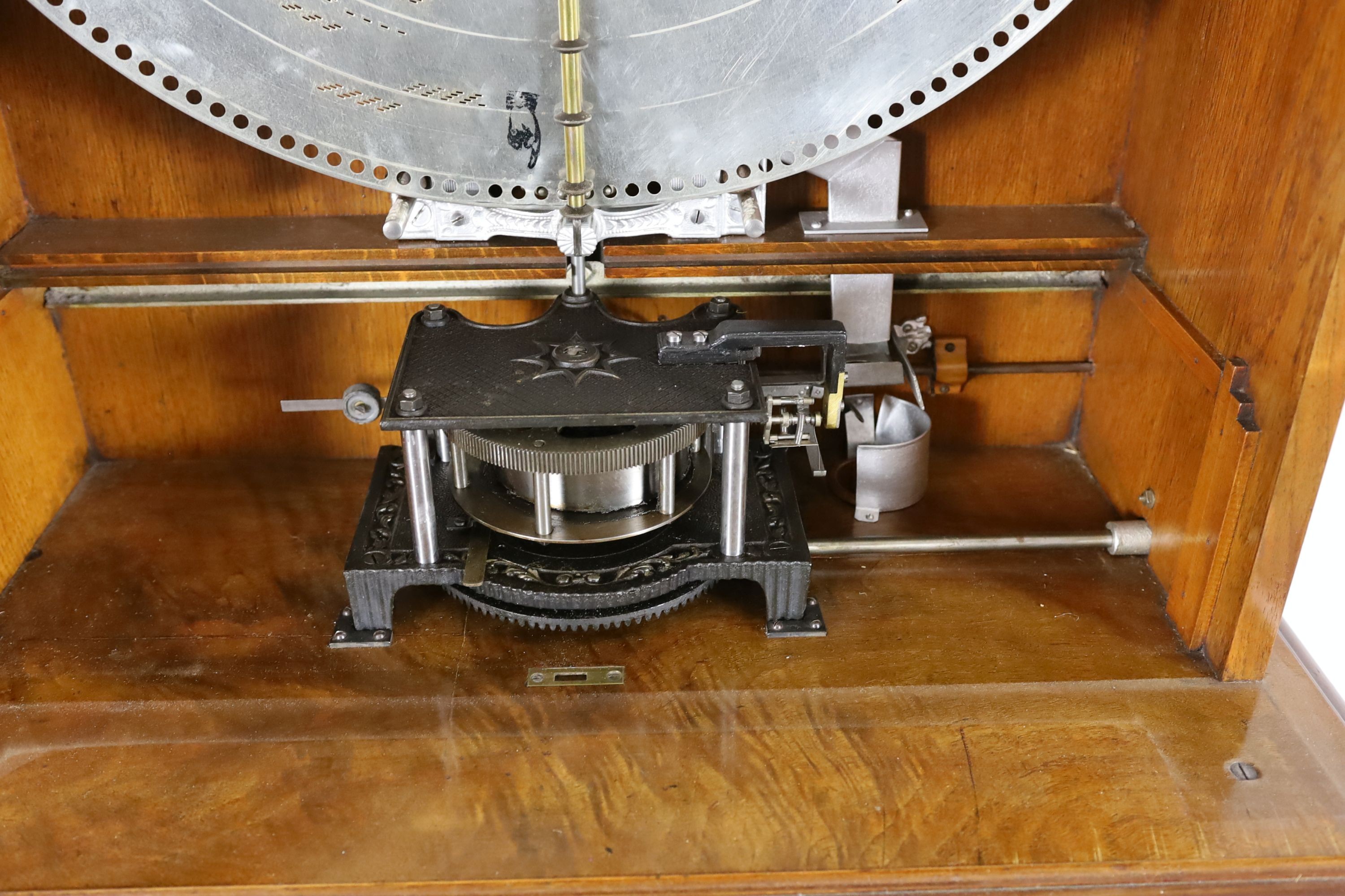A 19th century oak and walnut cased coin operated Polyphon disc music player retailed by Nicole Freres Leipzig, the double vertical steel comb playing 24.5 inch discs, the carved column floor standing case with pierced p